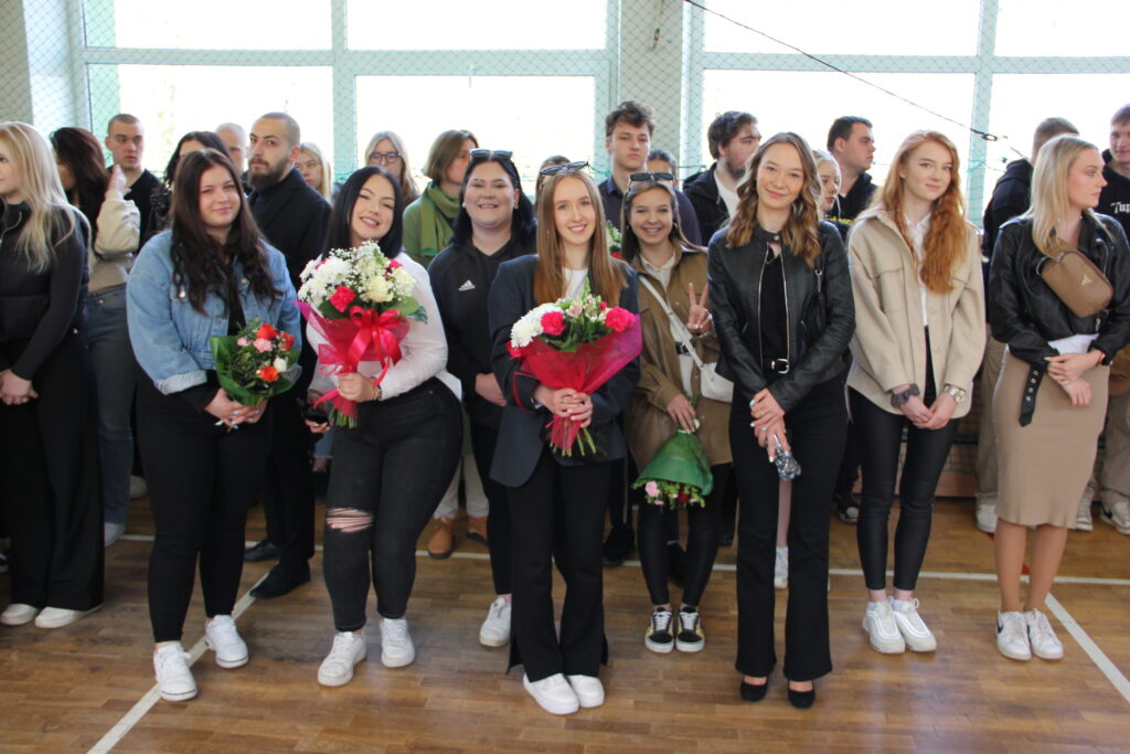 zdjęcie grupowe - sala gimnastyczna  - ostatni dzwonek - uczniowie z kwiatami