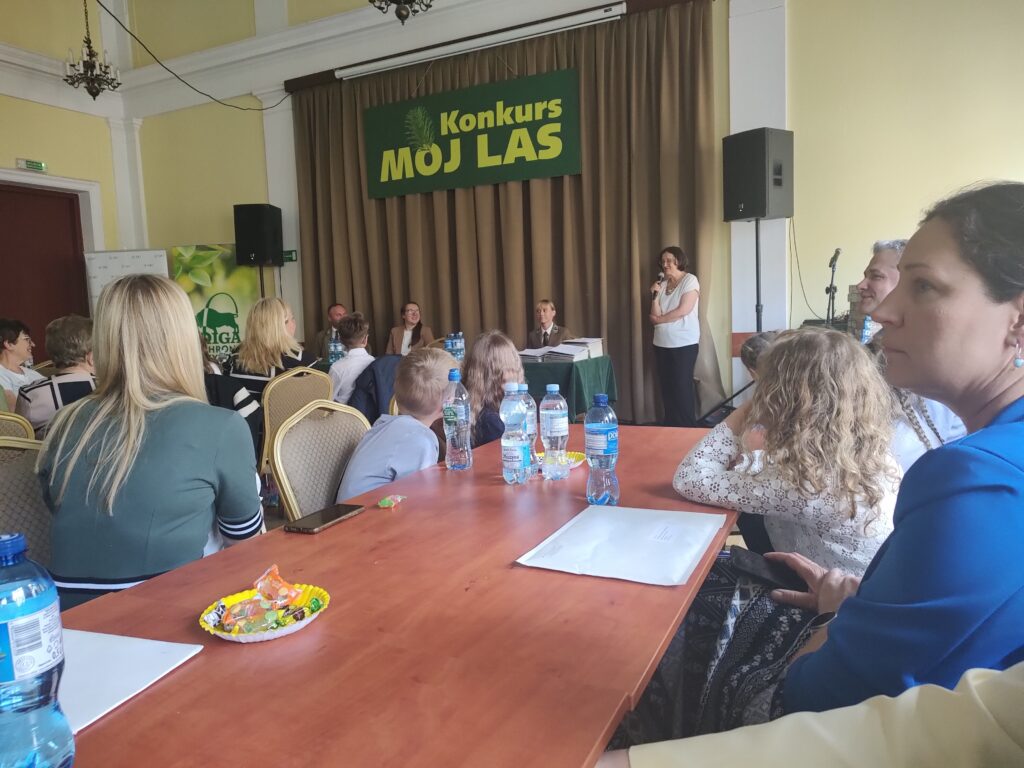 Uroczyste rozdanie nagród w ogólnopolskim konkursie Mój Las w czterech kategoriach wiekowych. Na planie są przedsawiciele organizatorów i uczestnicy konkursu wraz z opiekunami